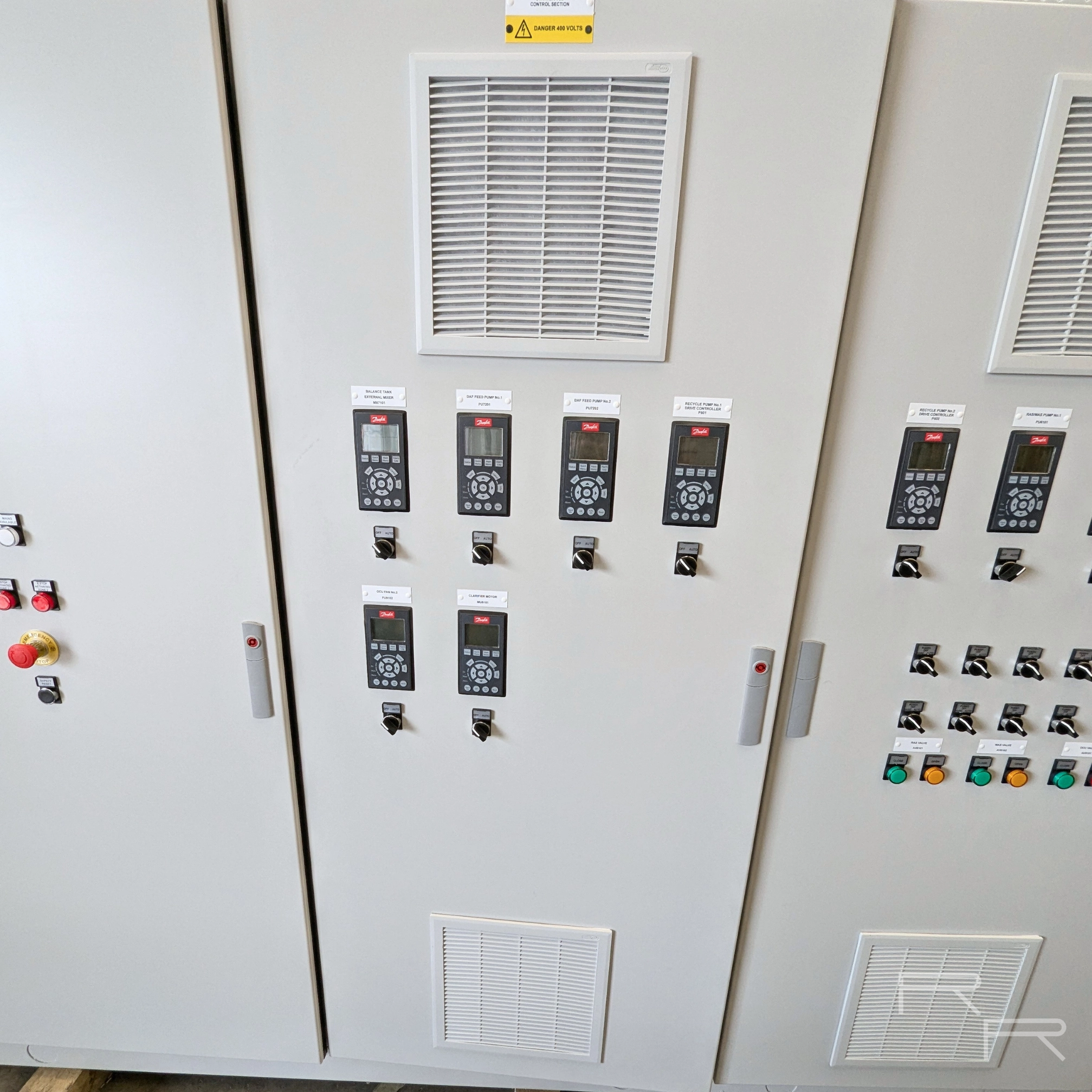 Door-mounted Danfoss drive parameter units with hand-off-auto selector switches, each labelled to its plant item